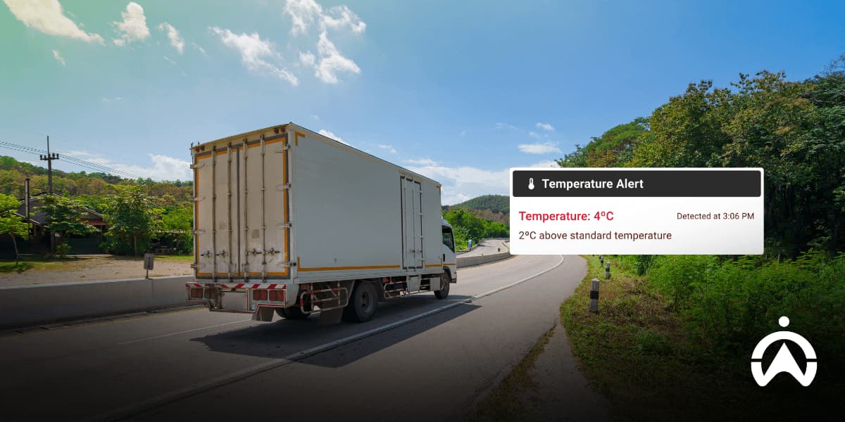 A white cargo truck on the road with a digital temperature alert, showcasing fleet management technology used to cut operational costs during summer.